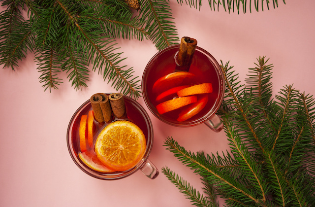 Glühwein in Tassen mit Orangen und Zimt